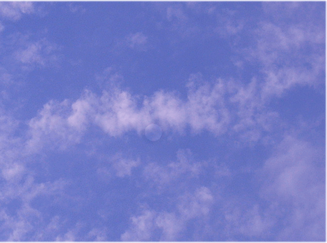 白い雲のまん中に、満月の昼の月
