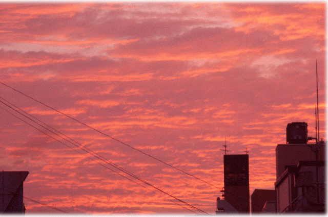 たなびく雲がピンクとオレンジに染まる夕暮れ。